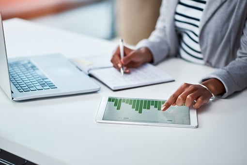 Making money work Shot of an unrecognizable businesswoman using a digital tablet with graphs on it in a modern office